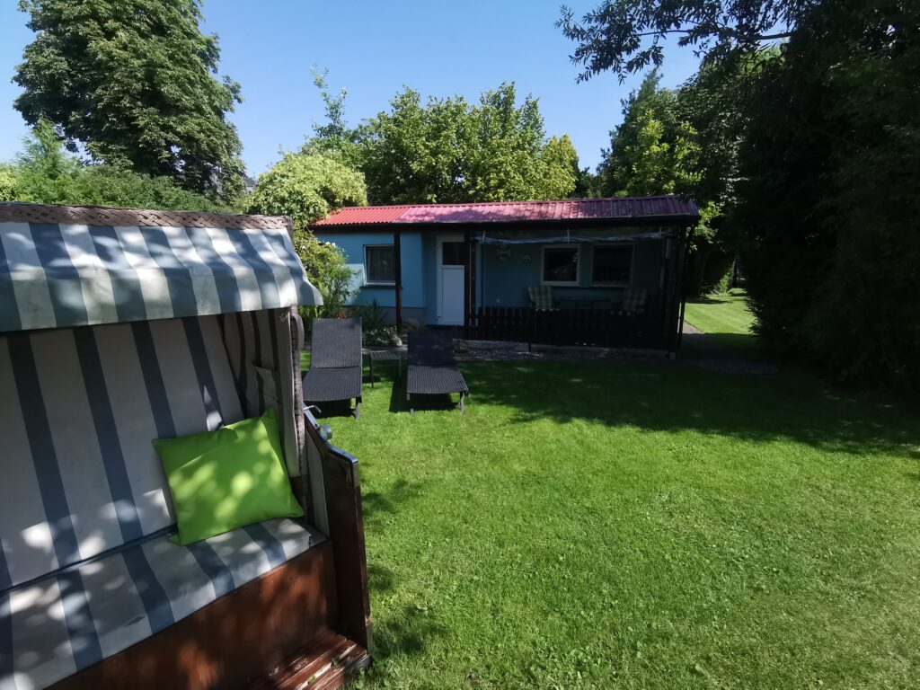 Garten mit Strandkorb und Liegen vor dem Strandhaus an der Müritz